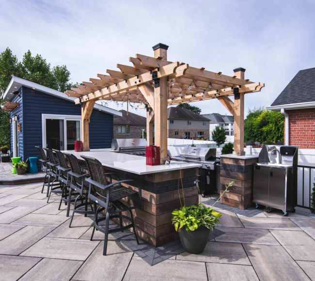 An outdoor kitchen with a pergola and bar stools.