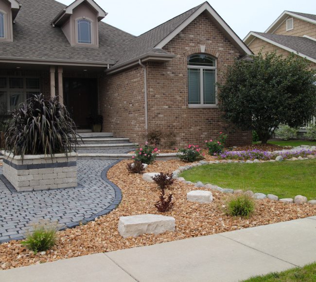 A front yard with a stone walkway and landscaping.